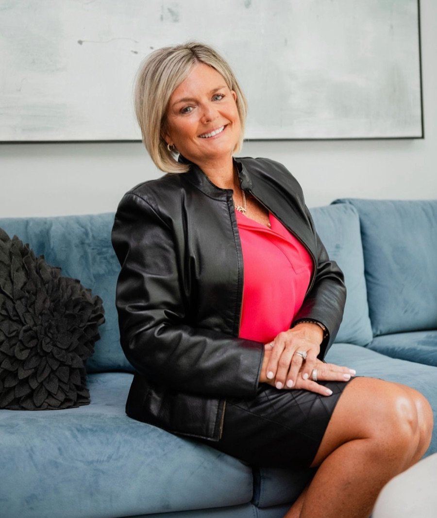 Lori Koza, Life Design Coach, seated on a blue sofa